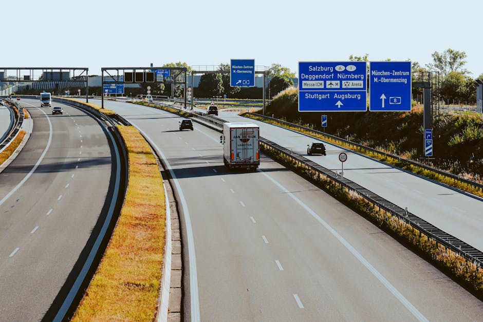 An aerial view of the German autobahn, showcasing traffic and road signs under clear skies.